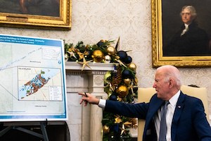 President Biden points at a graph during a briefing Monday with Homeland Security Secretary Alejandro Mayorkas and other officials.