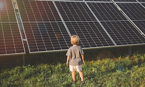 child standing in front of solar panels