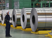 Worker looking at steel rolls